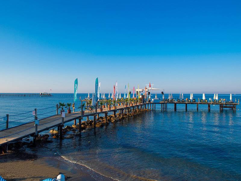 Turquoise Hotel Pier am Meer mit Sonnenschirmen und Pflanzen