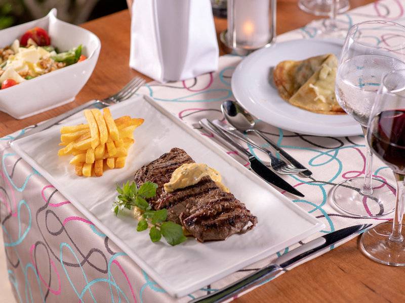 Ein Steakteller mit Pommes Frites und Salat im Turquoise Hotel.