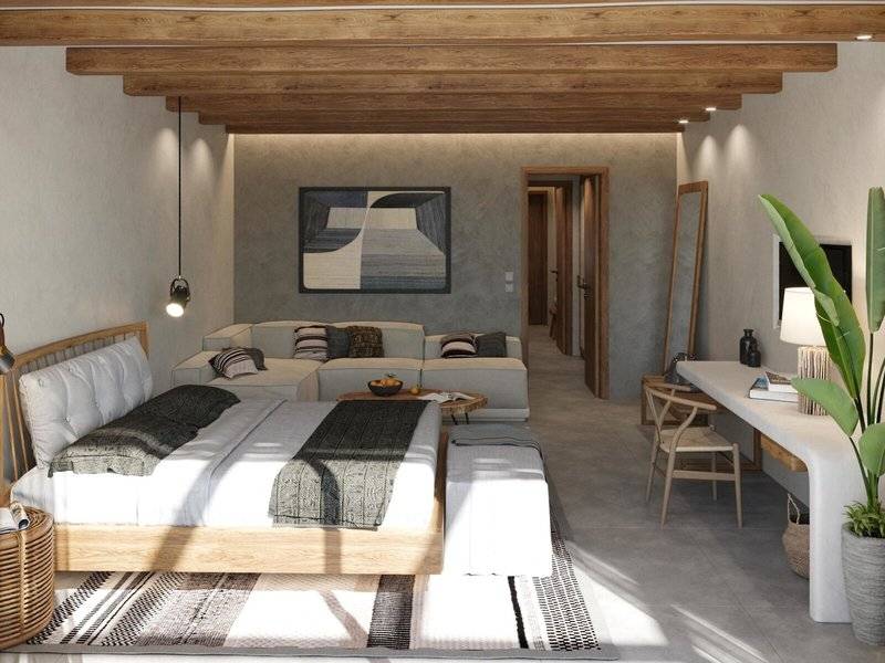 Modernes Hotelzimmer im JAZ Riviera mit Holzbalkendecke, einem großen Bett und Wohnbereich.