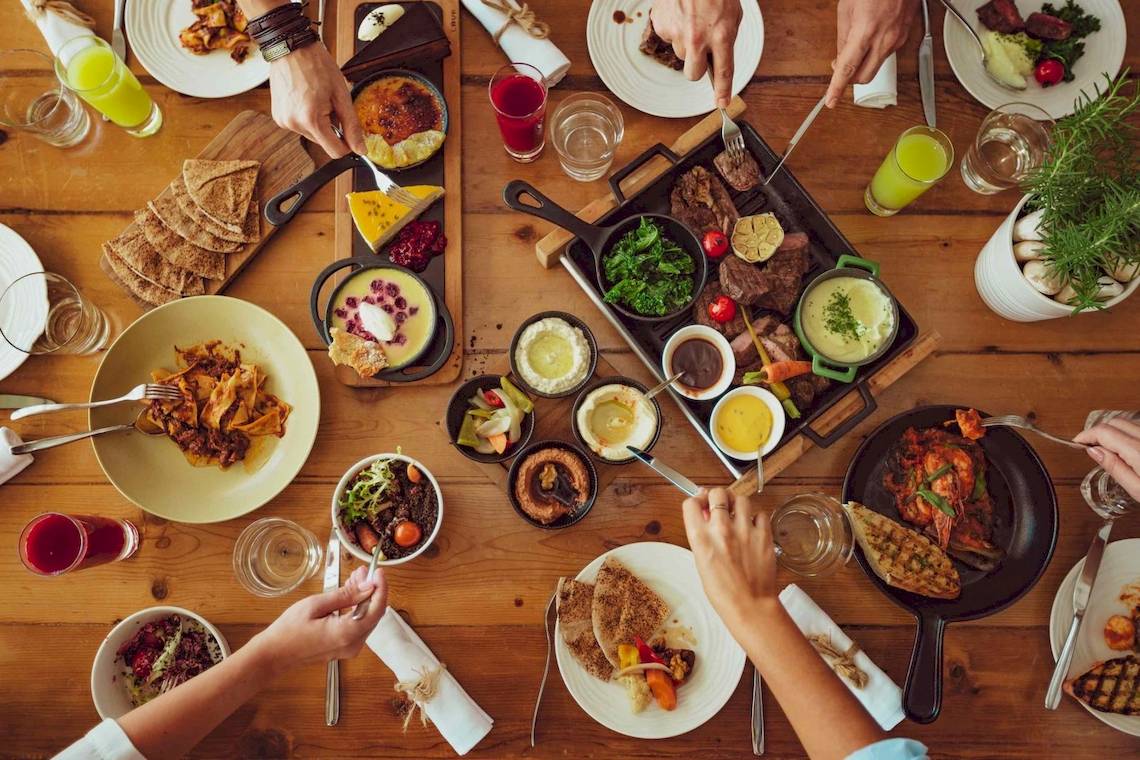Gruppe von Menschen, die ein Buffet im Nikki Beach Resort & Spa Dubai genießen.