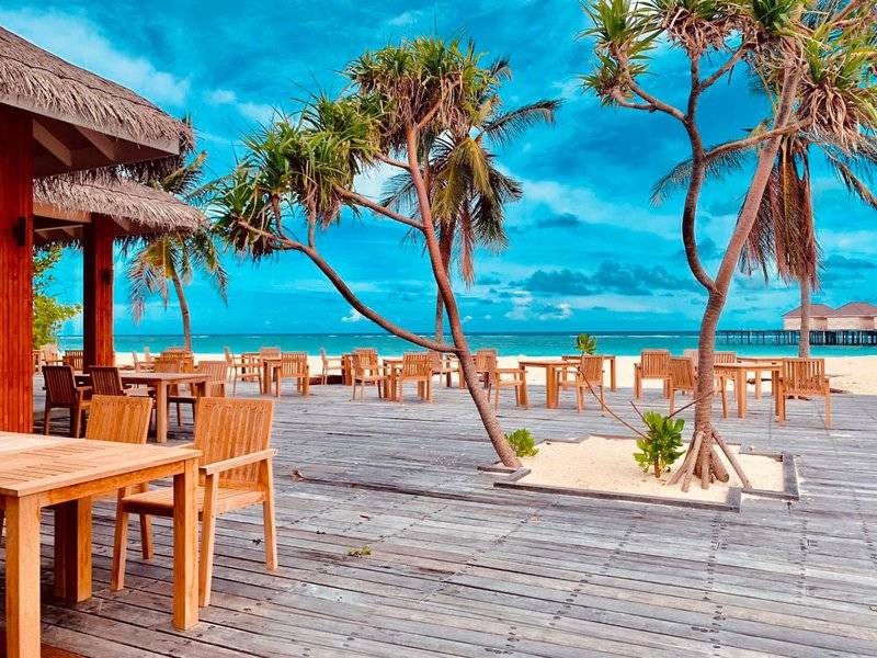 Restaurant mit Tischen und Stühlen auf der Strandterrasse im Brennia Kottefaru Maldives
