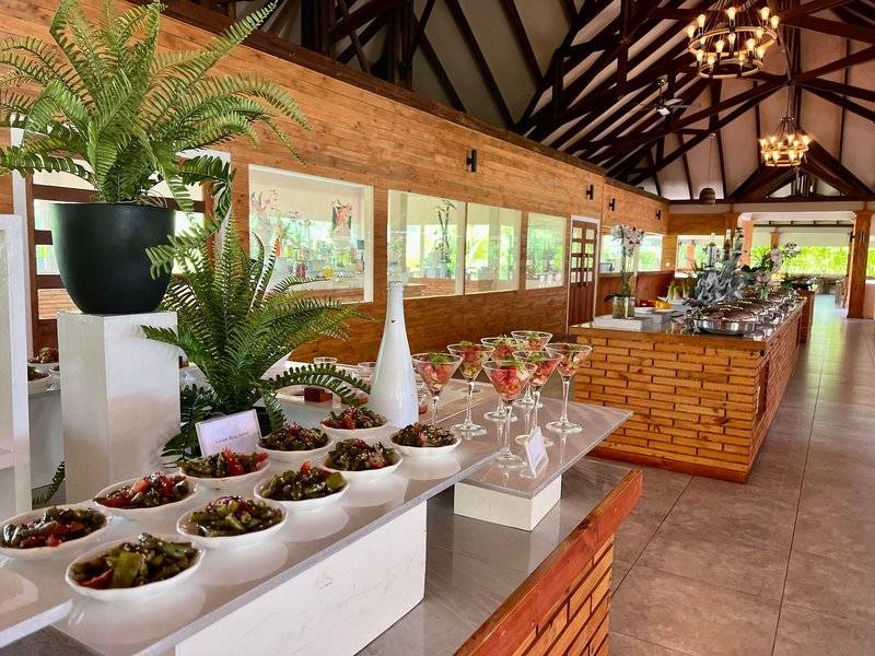 Buffettisch im Brennia Kottefaru Maldives mit verschiedenen Gerichten, Pflanzen und Cocktails.