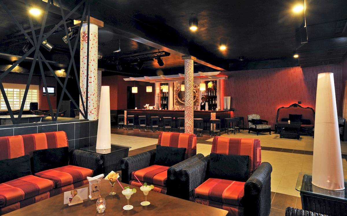 Innenansicht der Bar im Paradisus Varadero Resort & Spa mit Loungemöbeln, Cocktails und einer Bartheke.