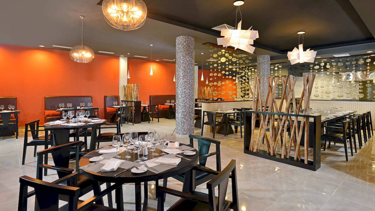Innenansicht des Restaurants im Paradisus Varadero Resort & Spa mit modernem Design, runden Tischen und Glasdekorationen.