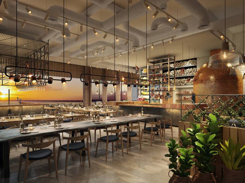 Innenansicht des Restaurants im Hilton Dubai Palm Jumeirah mit langen Tischen und Stühlen, hängenden Lampen und Pflanzen.