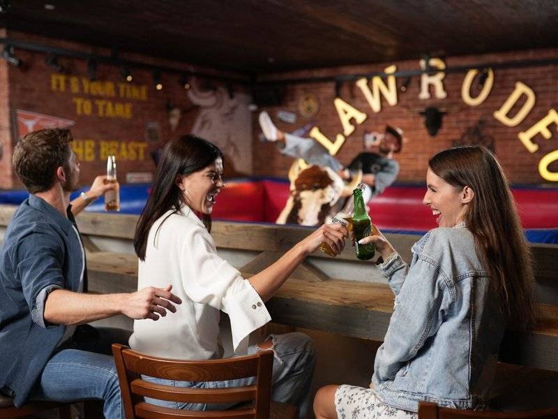 Besucher sitzen an der Bar des Hilton Dubai Palm Jumeirah und lachen.