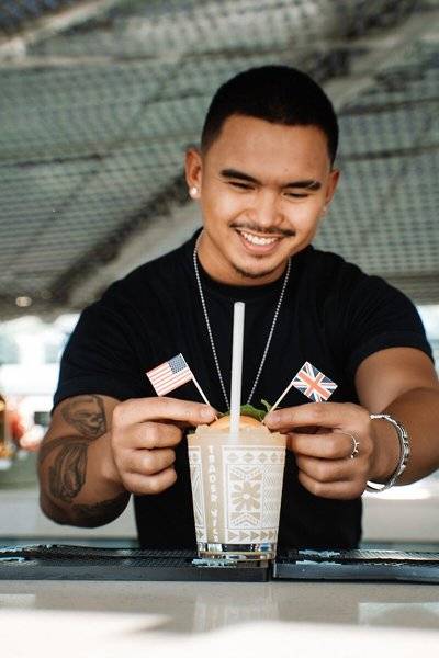 Barkeeper des Hilton Dubai Palm Jumeirah serviert einen Cocktail mit amerikanischen und britischen Flaggen.