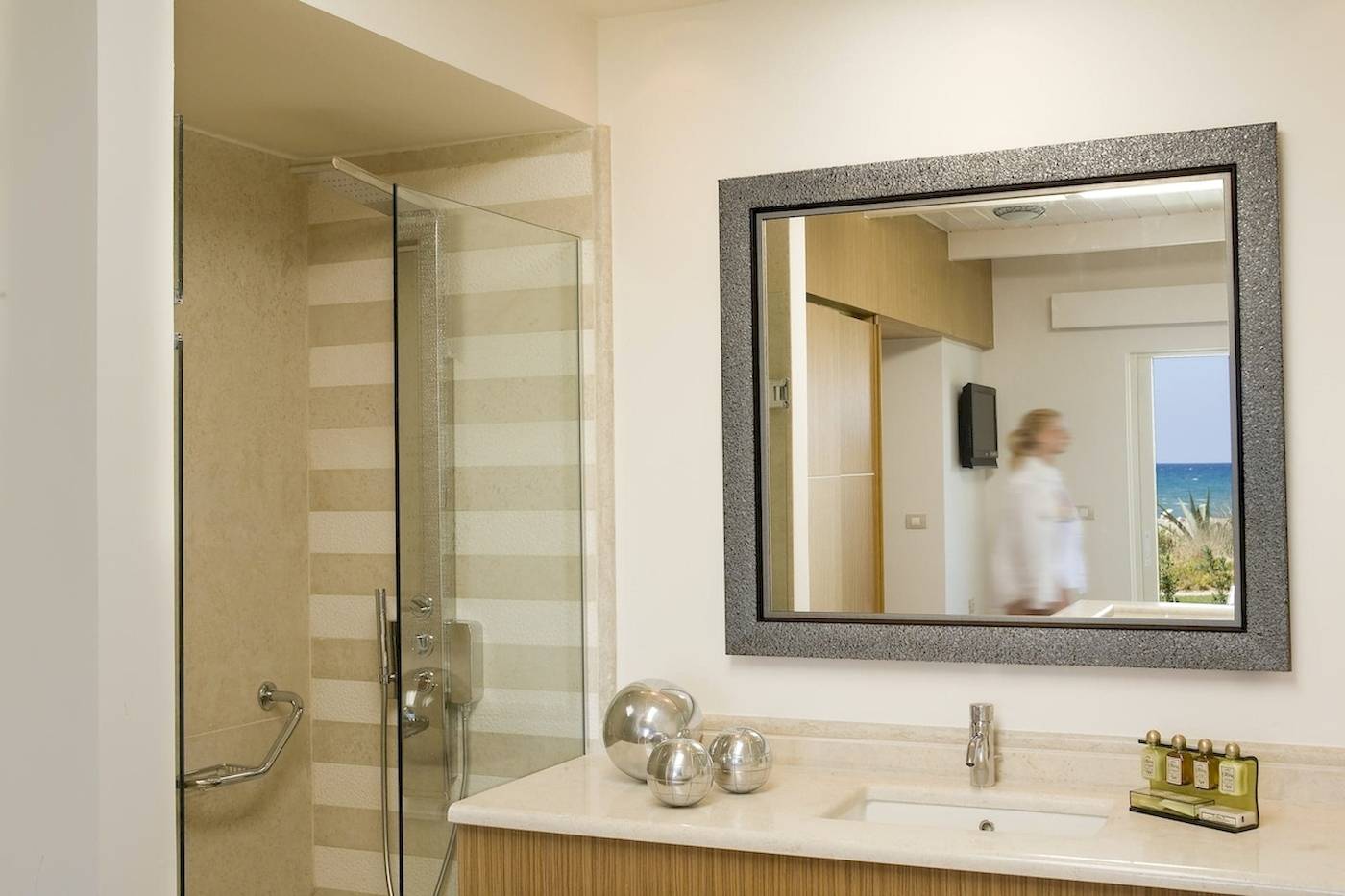 Badezimmer im Pilot Beach Resort mit Spiegel, Dusche und Meerblick.