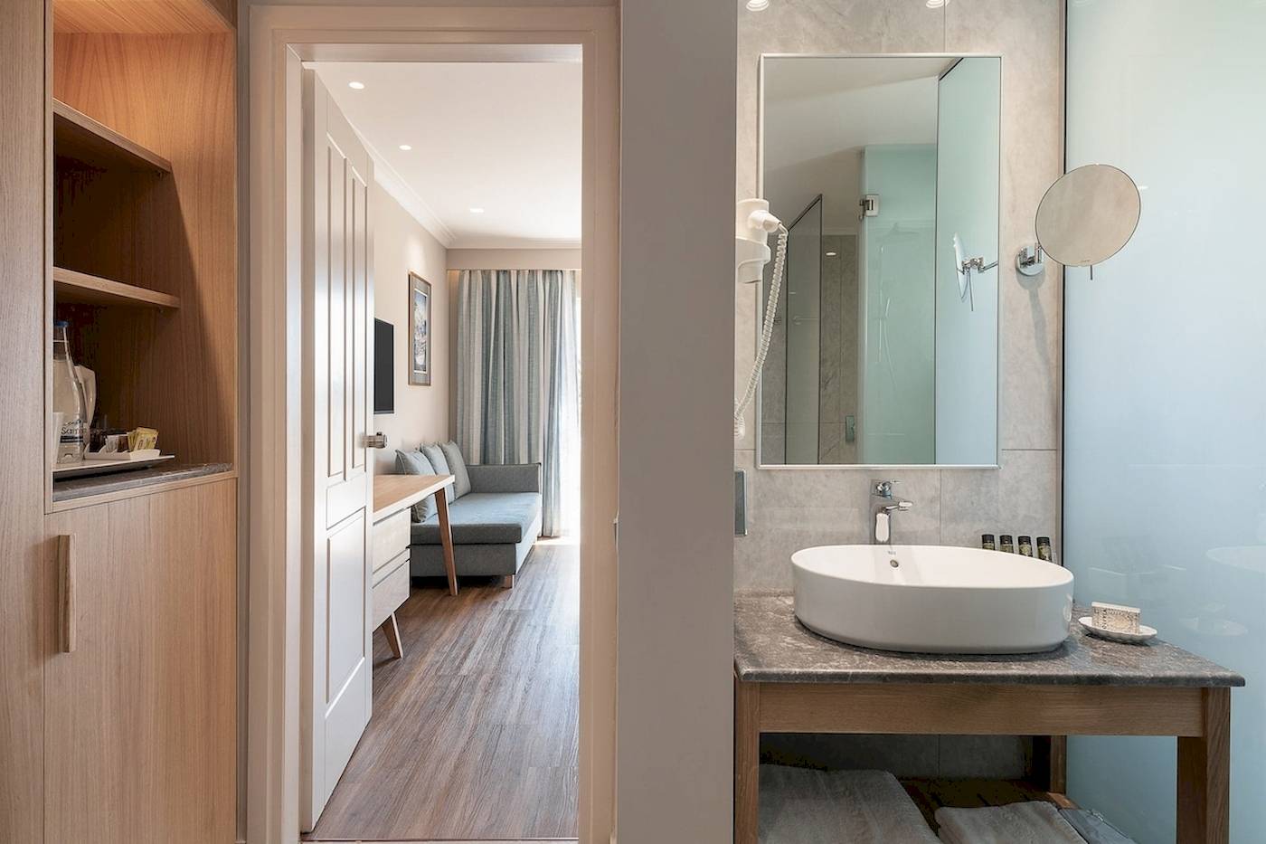 Badezimmer des Pilot Beach Resorts mit Waschbecken, Spiegel und Zugang zur Schlafzimmer.
