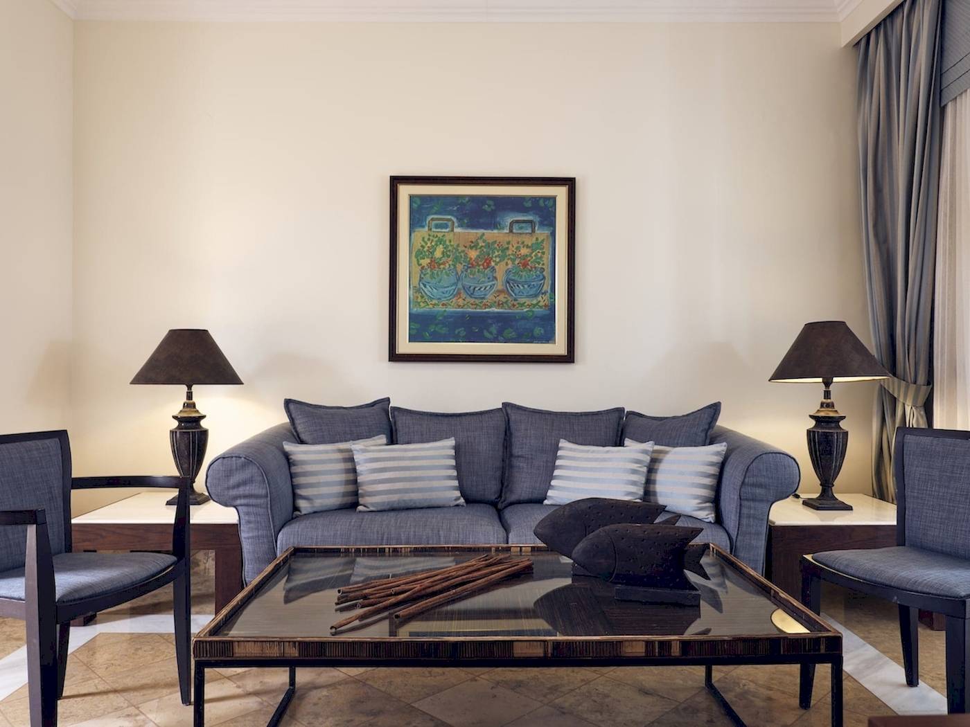 Wohnzimmer des Pilot Beach Resorts mit grauem Sofa, blauer Wand und Gemälde