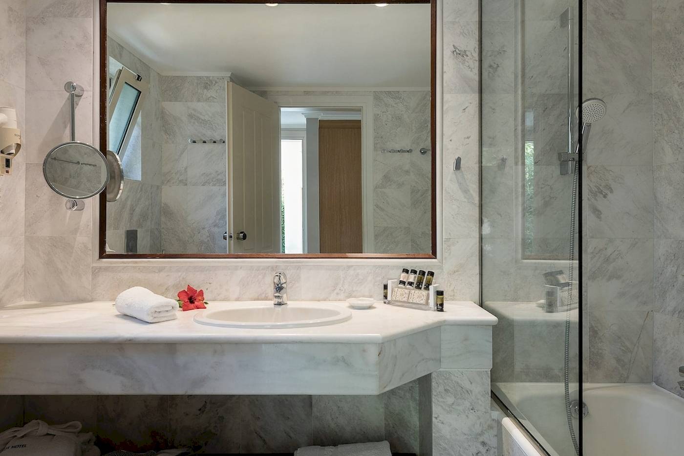 Badezimmer im Pilot Beach Resort mit großem Spiegel, Waschbecken und Badewanne.