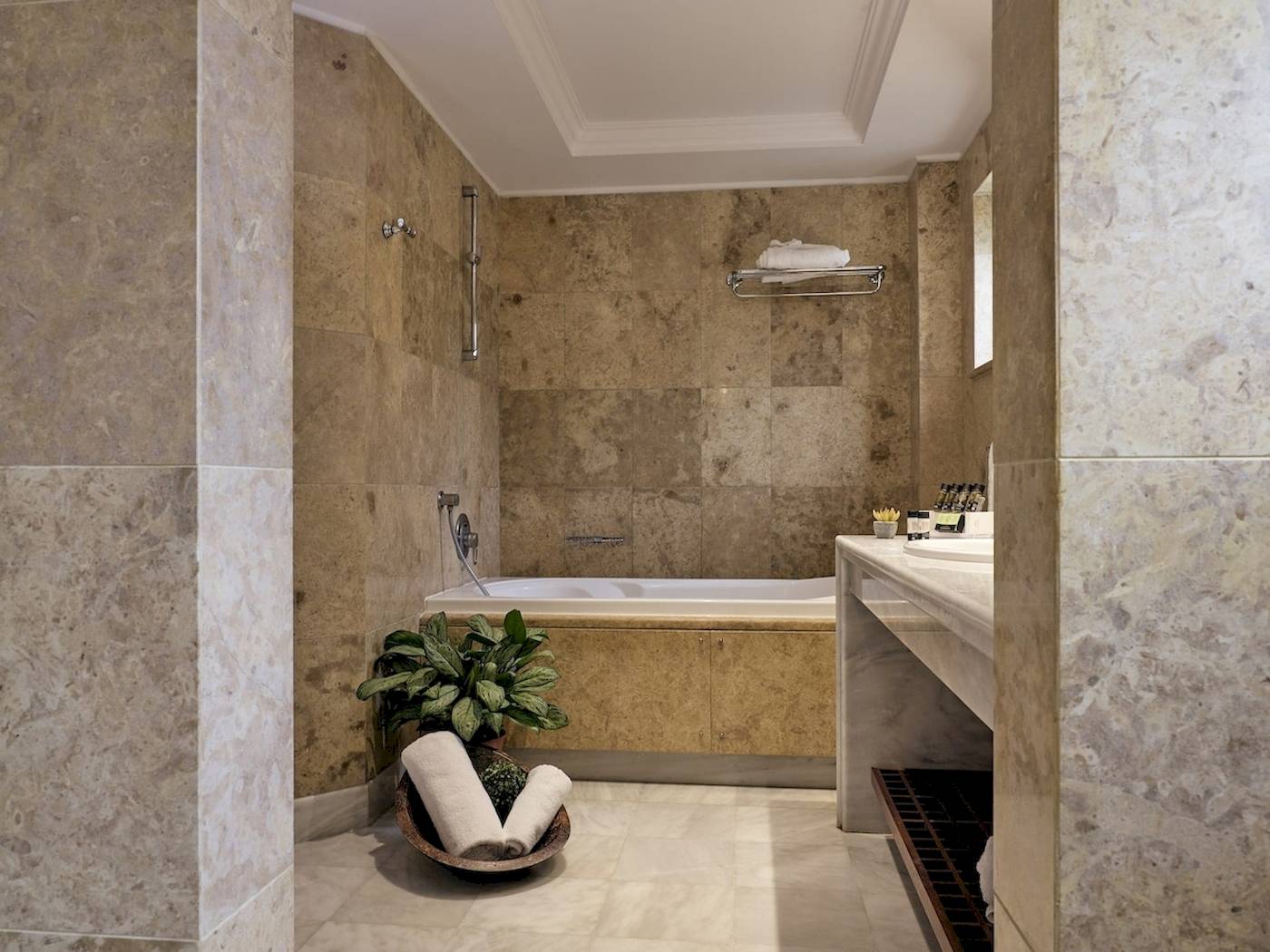 Ein Badezimmer im Pilot Beach Resort mit einer Badewanne, einer Pflanze und einem Waschbecken.