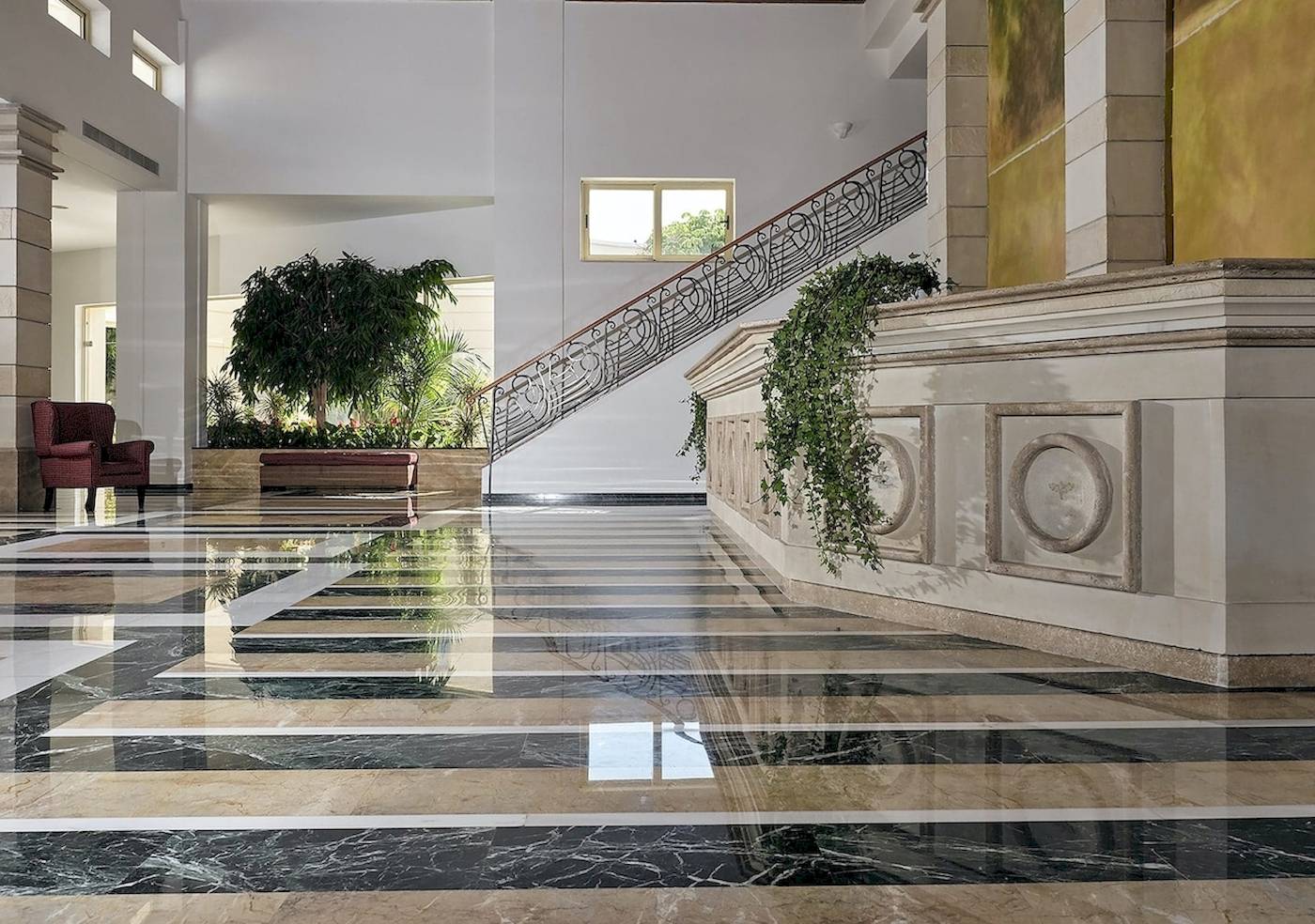 Foyer des Pilot Beach Resorts mit Marmorboden und geschwungener Treppe