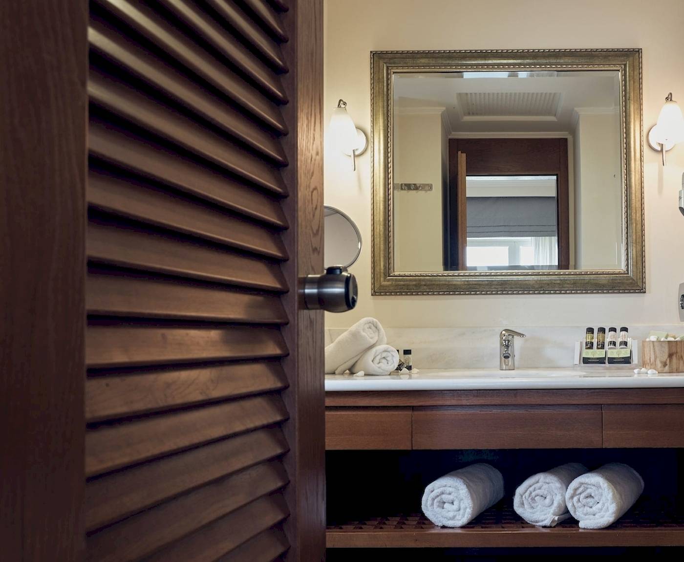 Badezimmer im Pilot Beach Resort mit Spiegel, Waschbecken und Handtüchern.