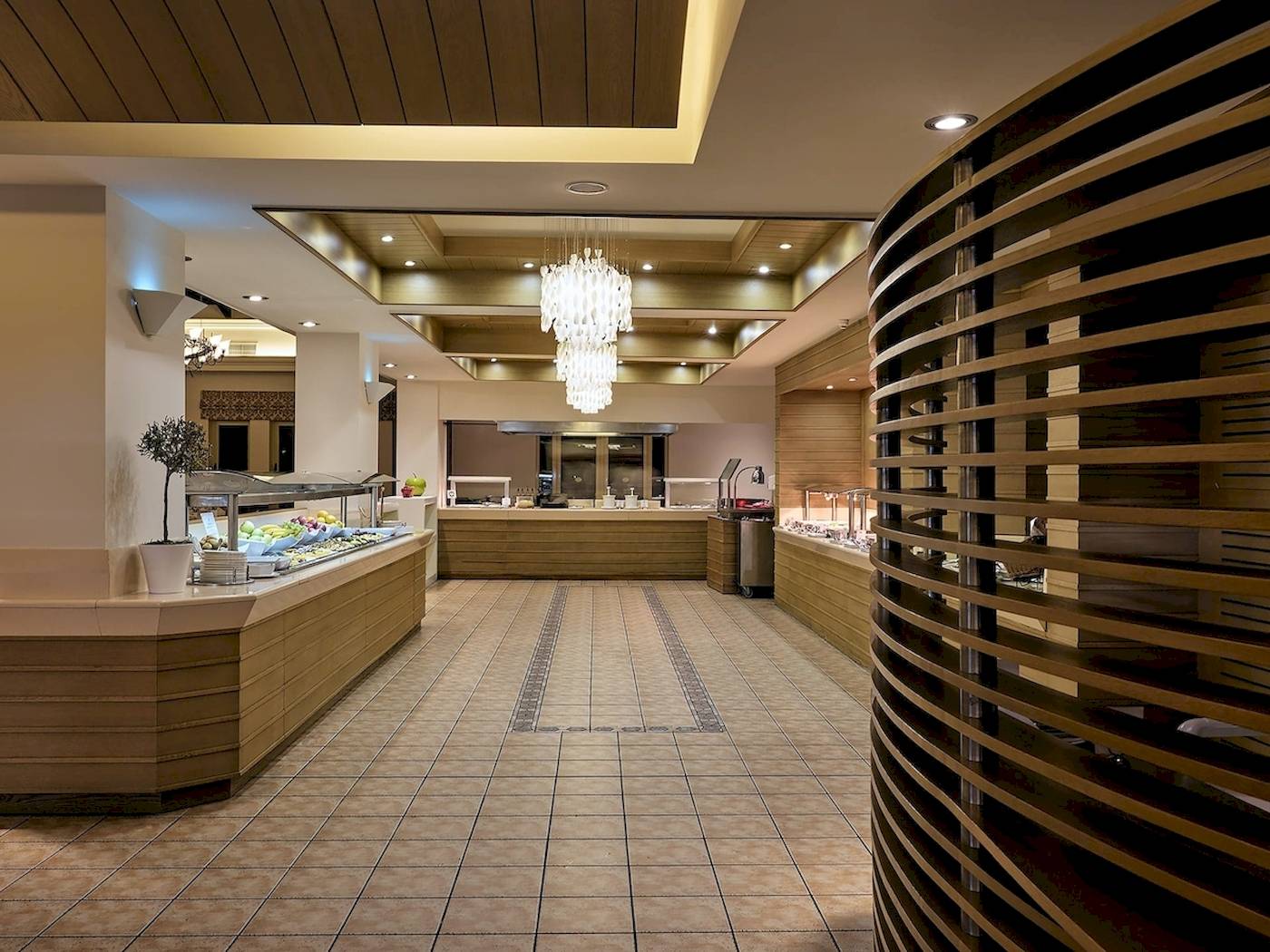 Innenbereich des Pilot Beach Resorts mit einem großen Buffet und einer geschwungenen Holzstruktur.