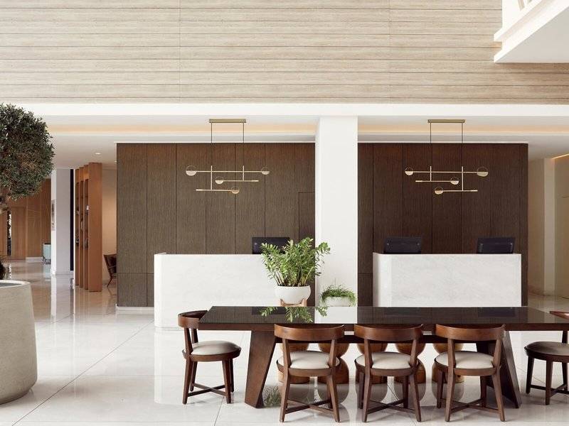 Lobby-Bereich des Mare Paphos Hotels mit Esstisch und Pflanzen.