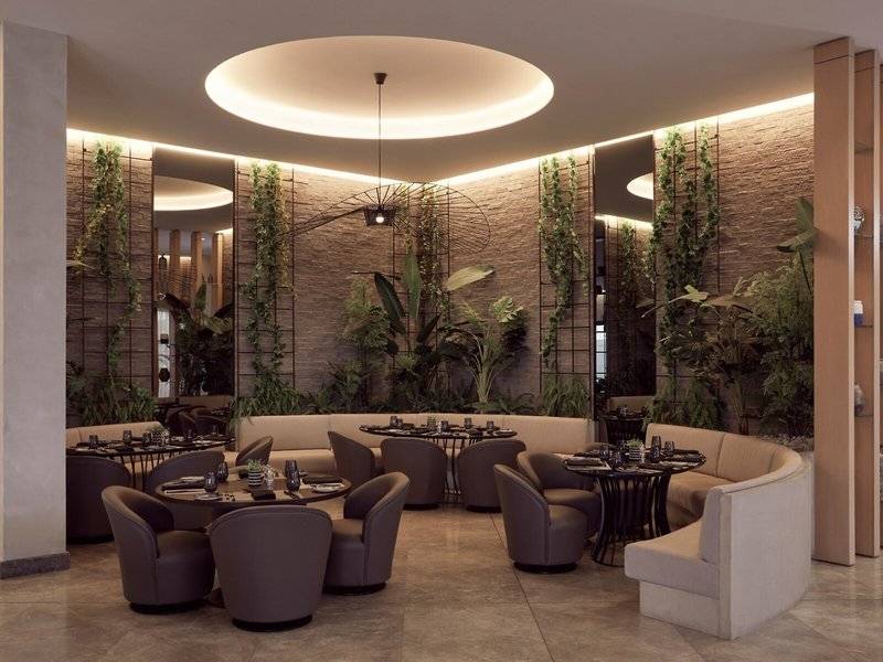 Interieurbereich des Mare Paphos Hotels mit grünen Pflanzenwänden und modernen Möbeln.