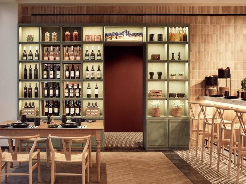 Innenbereich des Mare Paphos Hotels mit Esstisch, Stühlen und einer offenen Weinbar.