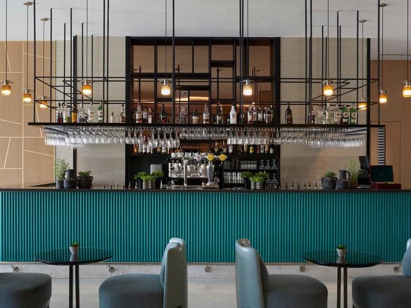 Innenansicht der Bar im Mare Paphos Hotel mit grüner Theke und schwarzen Stühlen.