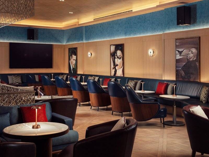 Loungebereich im St. Regis Al Mouj Muscat Resort mit modernen Möbeln und Kunstwerken.