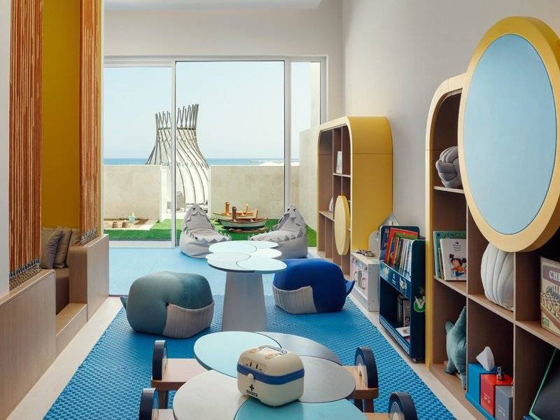 Kinderzimmer im St. Regis Al Mouj Muscat Resort mit bunten Möbeln und Spielzeug.