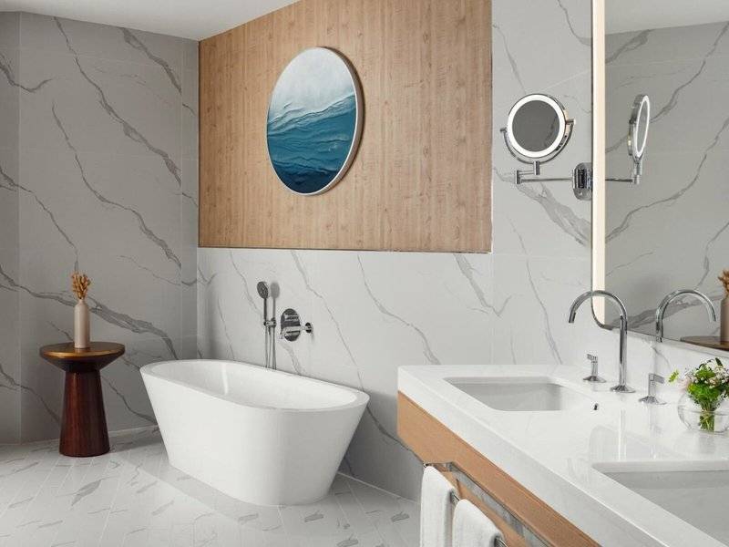 Badezimmer im St. Regis Al Mouj Muscat Resort mit Badewanne und Waschbecken.