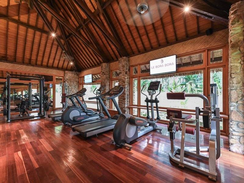Fitnessstudio im Le Bora Bora Hotel mit Holzboden und modernen Geräten.