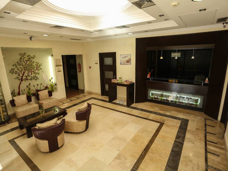 Lobby des Paradis Palace Hotels mit Sitzbereich, Rezeptionstresen und Spa-Anzeige