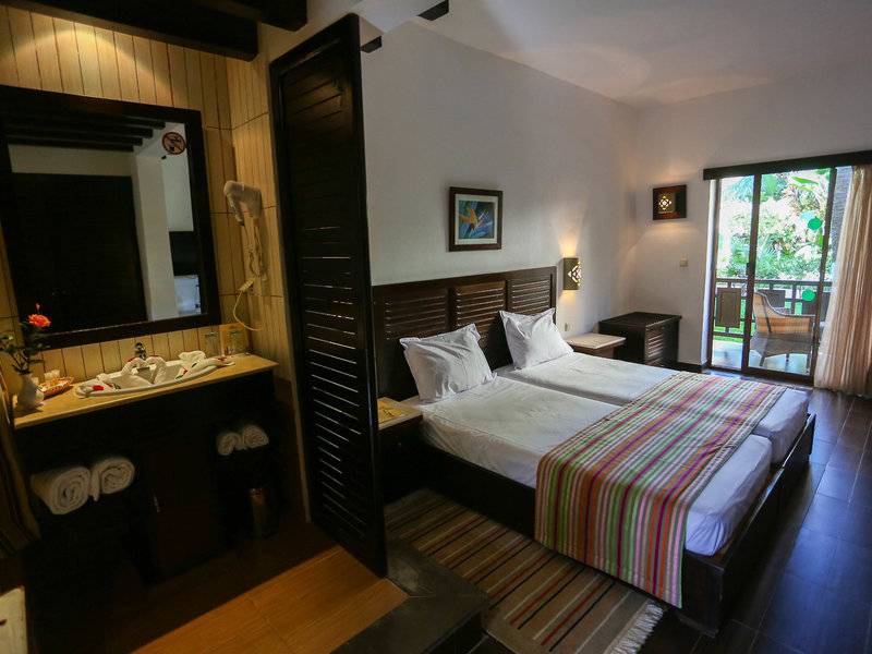 Doppelzimmer im Paradis Palace Hotel mit zwei Betten, einem Badezimmer und einer Terrasse.