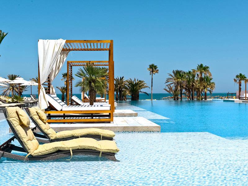 Ein großer Pool mit Liegen und Sonnenschirmen am JAZ Tour Khalef Hotel