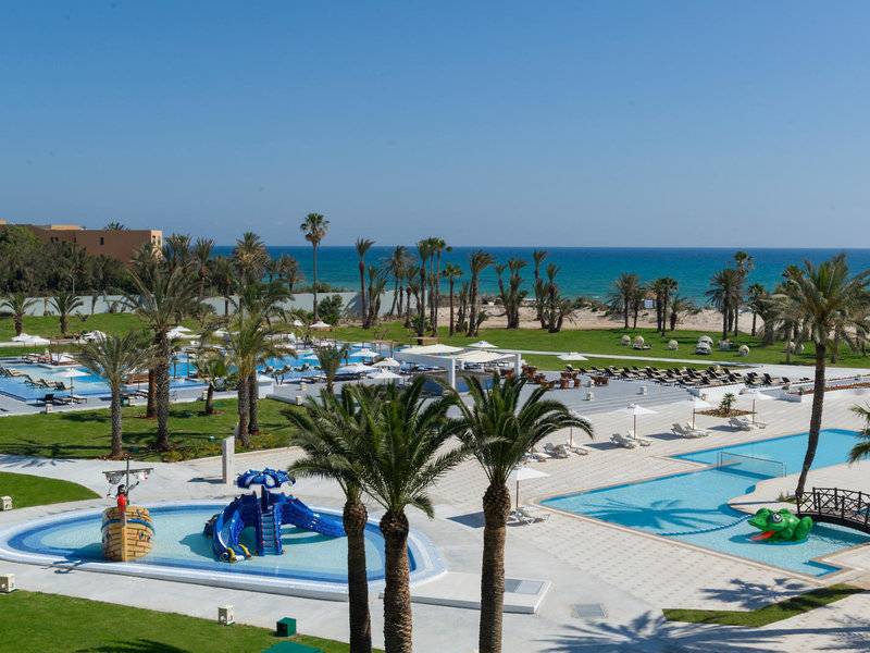 Luftaufnahme des JAZ Tour Khalef Resorts mit Swimmingpools, Palmen und Meer im Hintergrund.