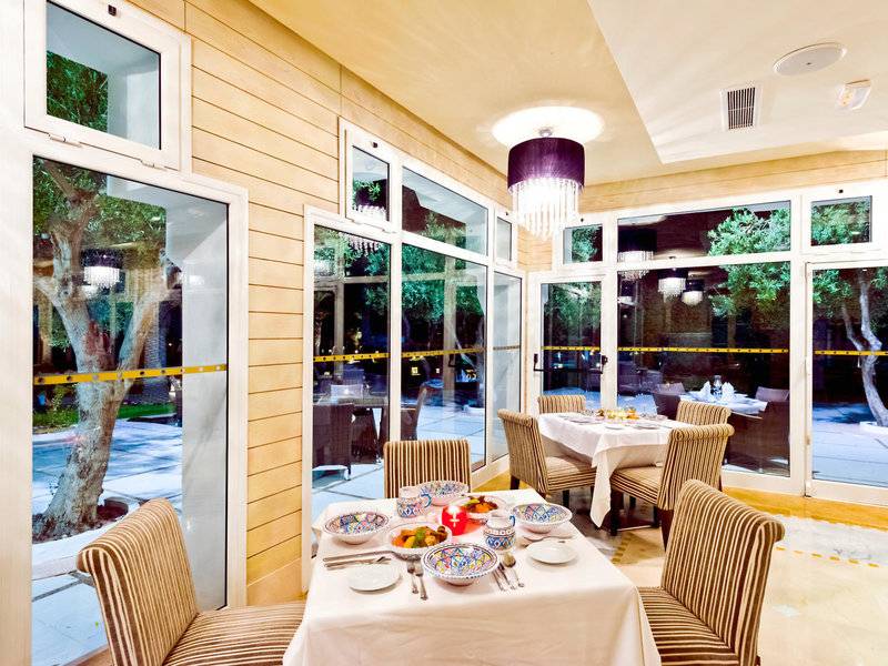 Innenansicht des Speisesaals im Jaz Tour Khalef Hotel mit großen Fenstern und moderner Einrichtung.