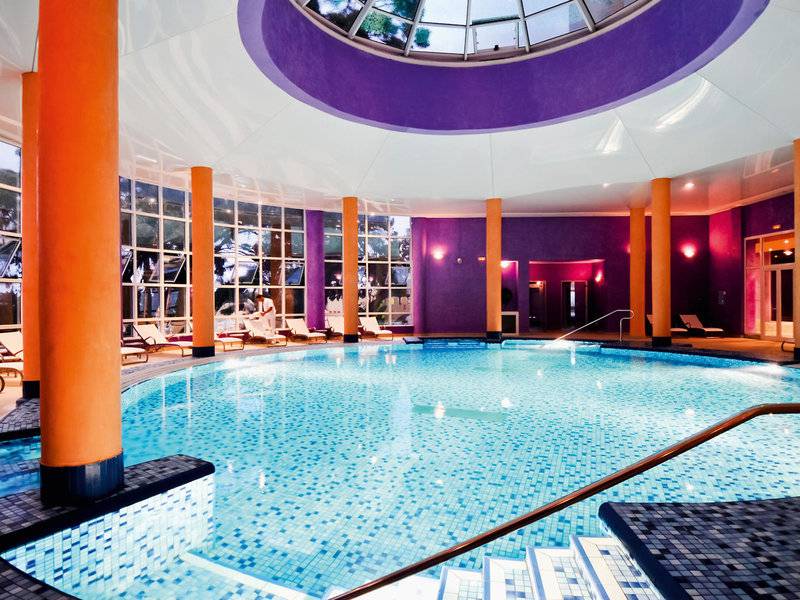Innenpool im JAZ Tour Khalef Hotel mit blauen Fliesen und orangefarbenen Säulen.