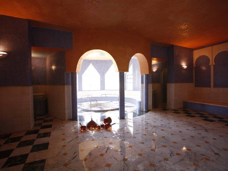 Innenbereich des JAZ Tour Khalef Hotels mit einem Schwimmbad und Marmorboden.