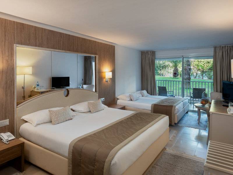 Hotelzimmer im JAZ Tour Khalef mit zwei Betten, großem Spiegel und Balkon.