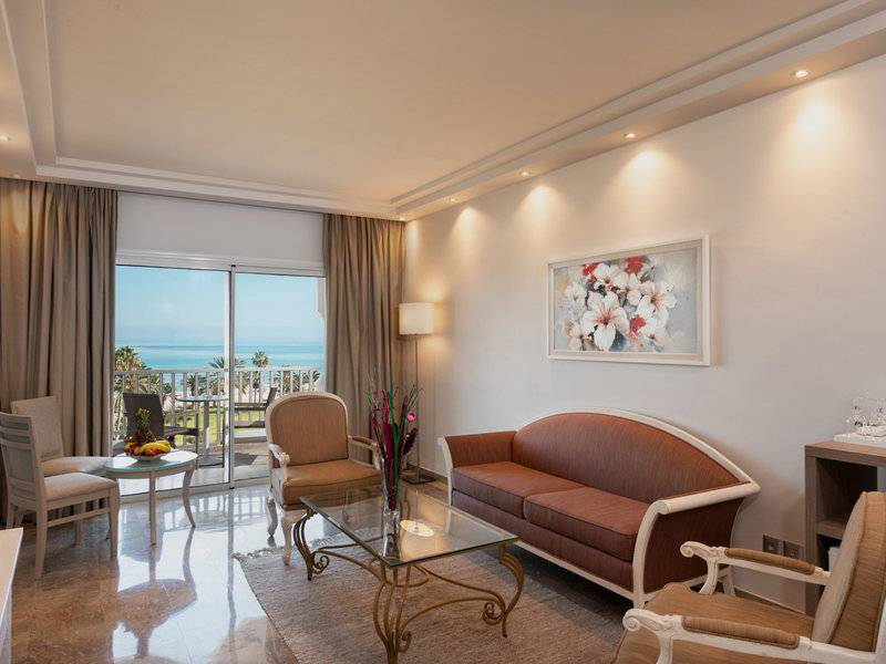 Hotelzimmer im JAZ Tour Khalef mit Meerblick, modern eingerichtet mit Couch, Tisch und Fenstern.