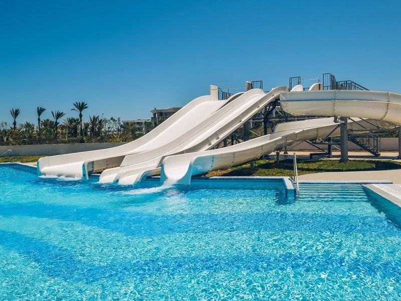Wasserrutschen im Iberostar Selection Kuriat Palace Hotel mit blauem Pool und blauem Himmel.