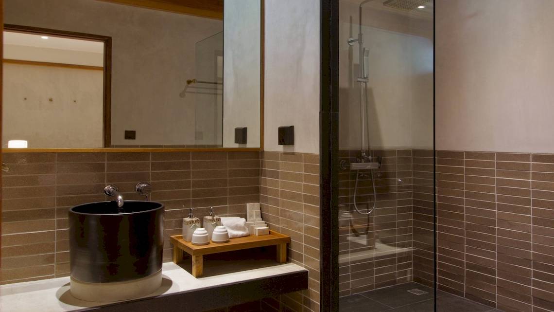 Badezimmer im Banana Fan Sea Resort mit schwarzem Waschbecken und braunen Fliesen.