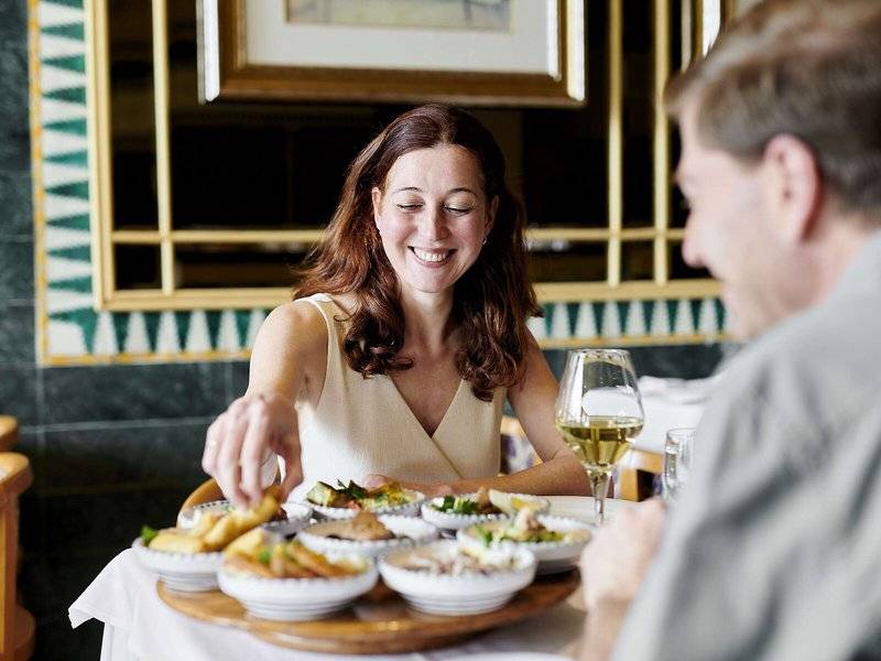 Frau und Mann essen im Iberostar Selection Kantaoui Bay Hotel mit verschiedenen Gerichten auf einem Tablett