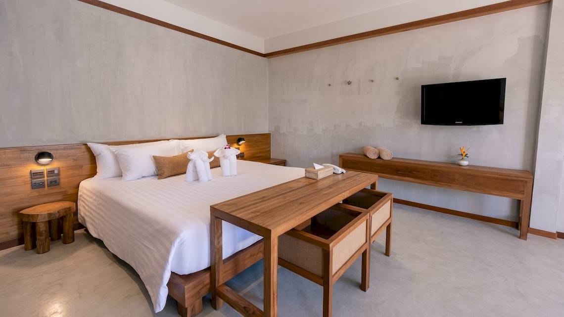 Innenansicht eines Hotelzimmers mit Doppelbett, Nachttischen, Fernseher an der Wand und Dekor