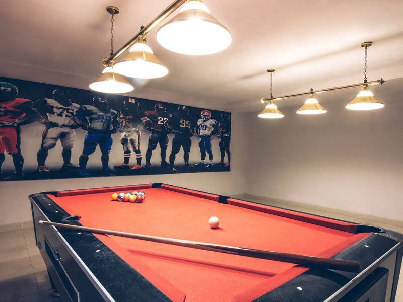 Ein Pooltisch in einem Raum des Hotels Iberostar Selection Diar El Andalous, mit einer Wandbild von American Football Spielern.