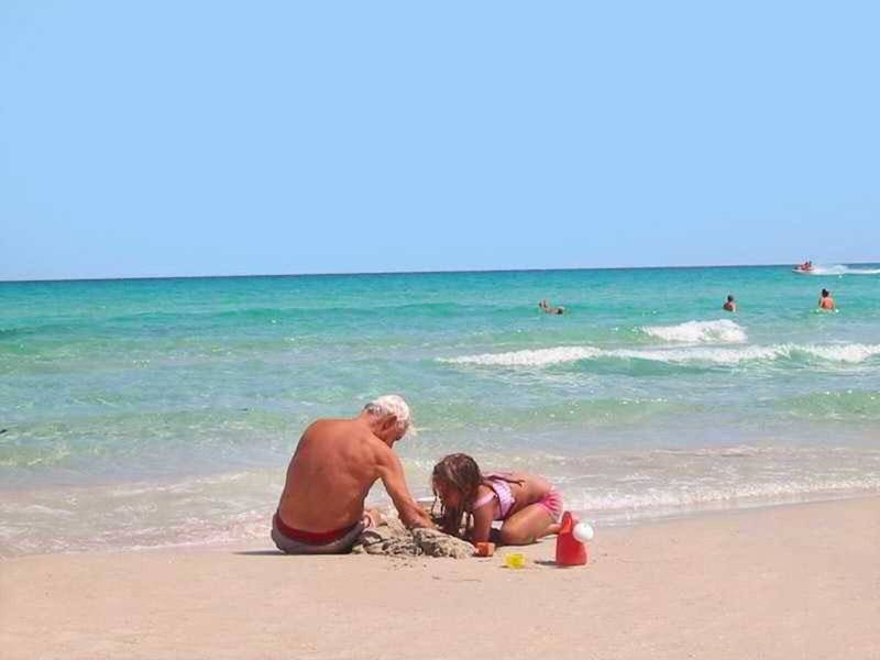 Großvater und Enkelin bauen eine Sandburg am Strand des Mahdia Palace Thalasso