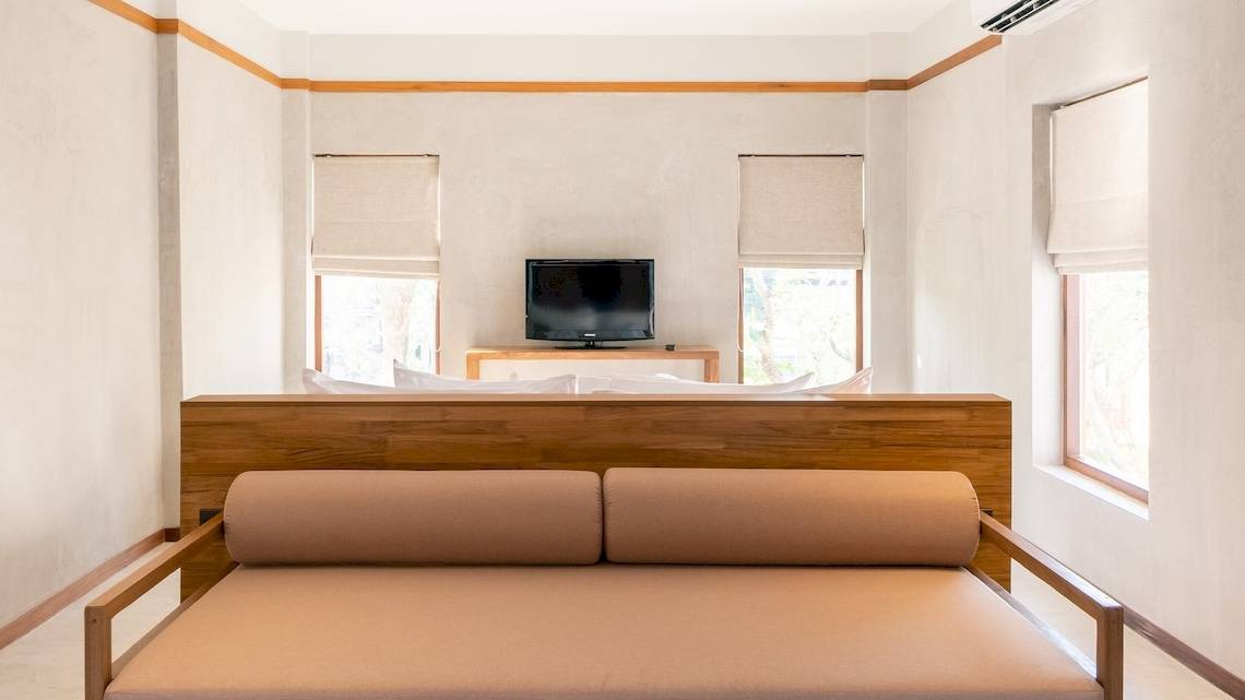 Innenansicht eines Schlafzimmers im Banana Fan Sea Resort mit Fernseher und Bett.