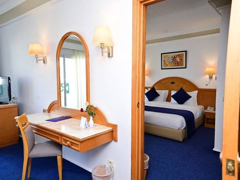 Innenansicht eines Hotelzimmers im Mahdia Palace Thalasso mit Schreibtisch, Stuhl, Spiegel und Bett