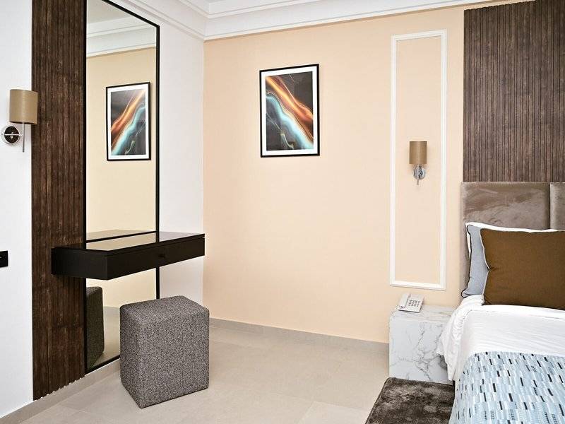 Innenansicht eines Zimmers im Mahdia Palace Thalasso mit Bett, Schreibtisch und Spiegel.