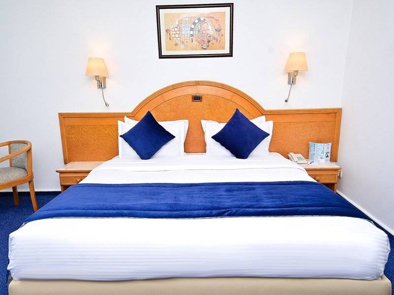 Hotelzimmer im Mahdia Palace Thalasso mit Doppelbett, blauer Bettwäsche und weißem Kopfteil.
