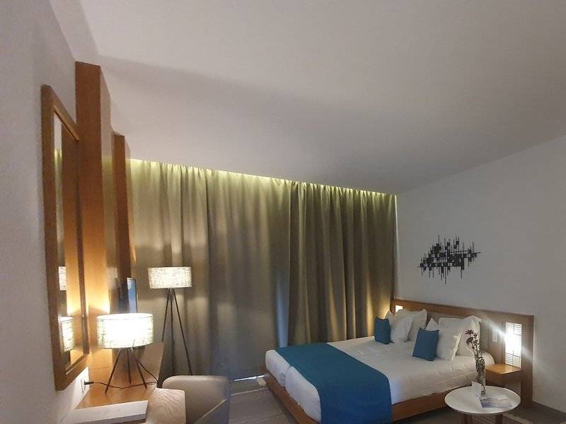 Schlafzimmer im Orangers Garden Villas & Bungalows mit Bett, Lampen und Dekoration.