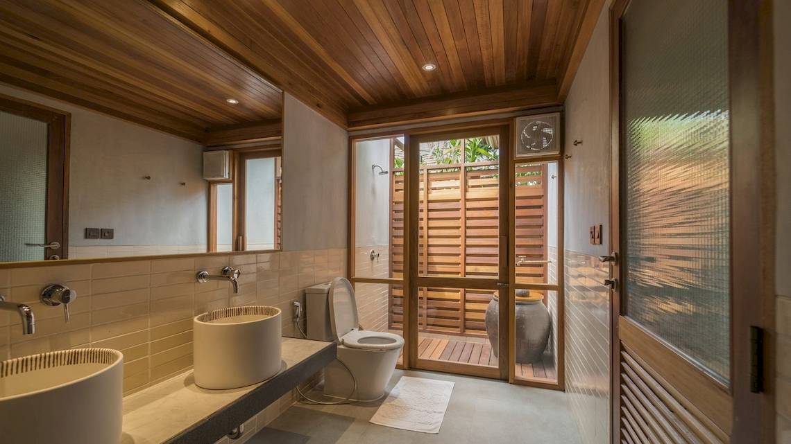 Ein Badezimmer mit zwei Waschbecken, einer Toilette und einer Glastür, die zu einer Dusche führt.