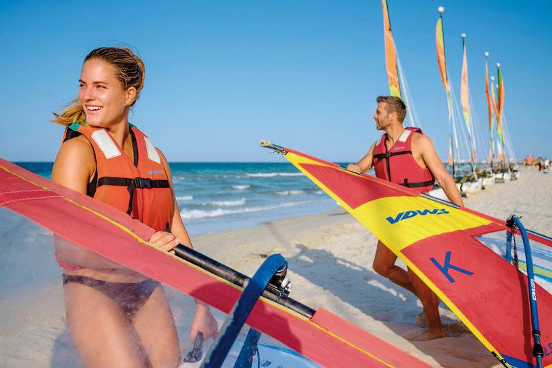Zwei Personen in orangenen Windsurfer-Westen am Strand von Aldiana Club Djerba Atlantide.