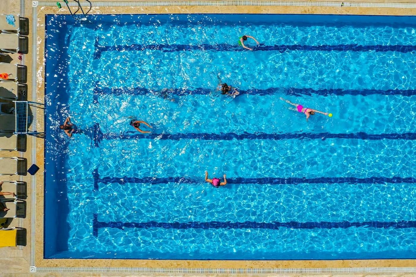 Mehrere Personen schwimmen im Club Wasa Holiday Village Schwimmbad.